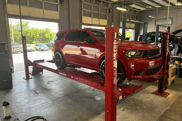 Car lifted in garage bay Car lifted in garage bay