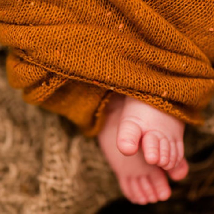 Baby feet sticking out of a baby. 