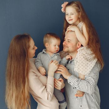 Family of four posing and looking content. 