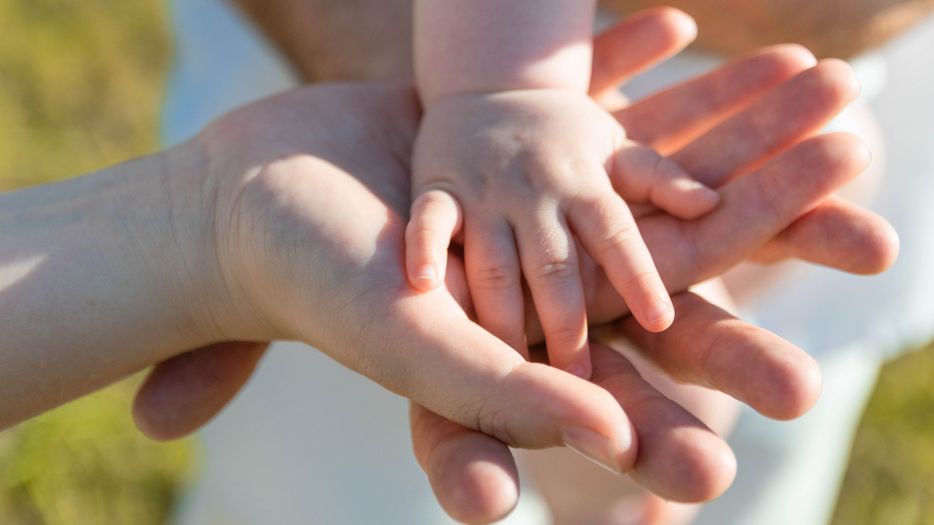 Family with their hands stacked on top of one another. 