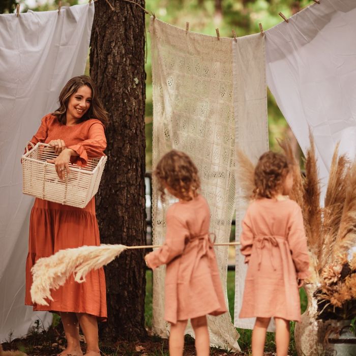 Mom holding a basket while smiling at her daughters. 