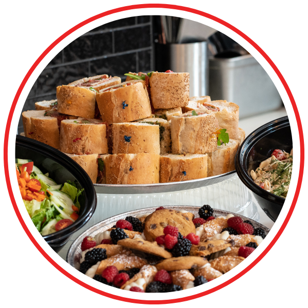 Catering spread with sandwiches, salads, and sweats