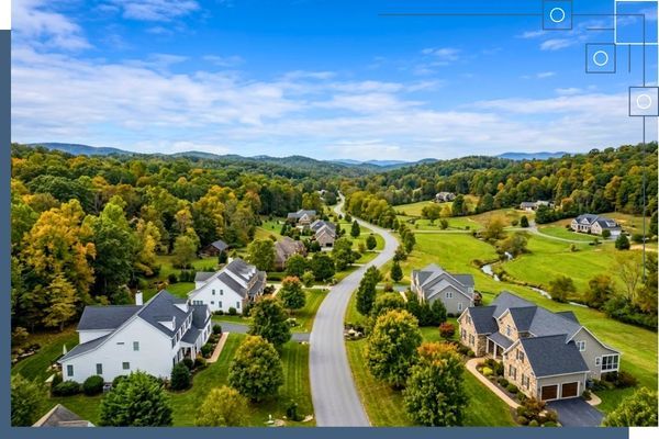 Aerial view of a premium residential neighborhood in a lush, wooded valley