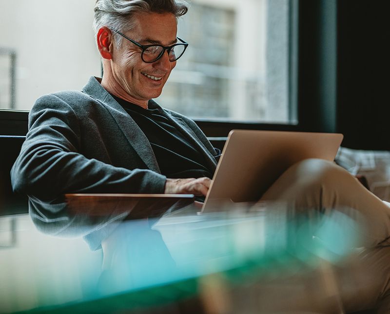 man sitting in an office chair with laptop