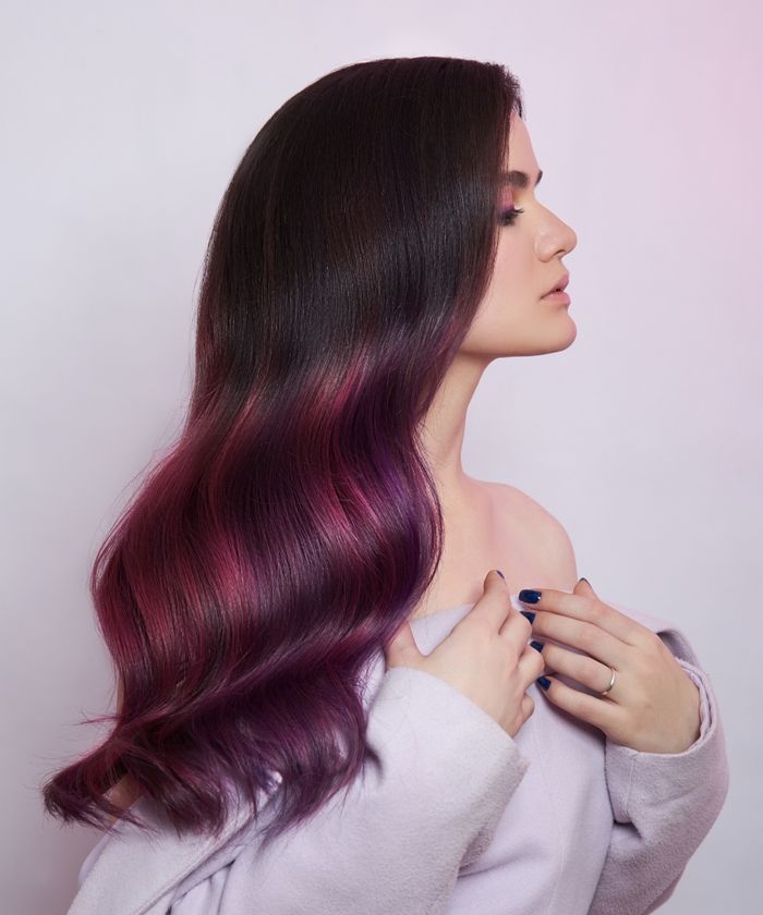 Woman with ombre hair fading from brown to magenta