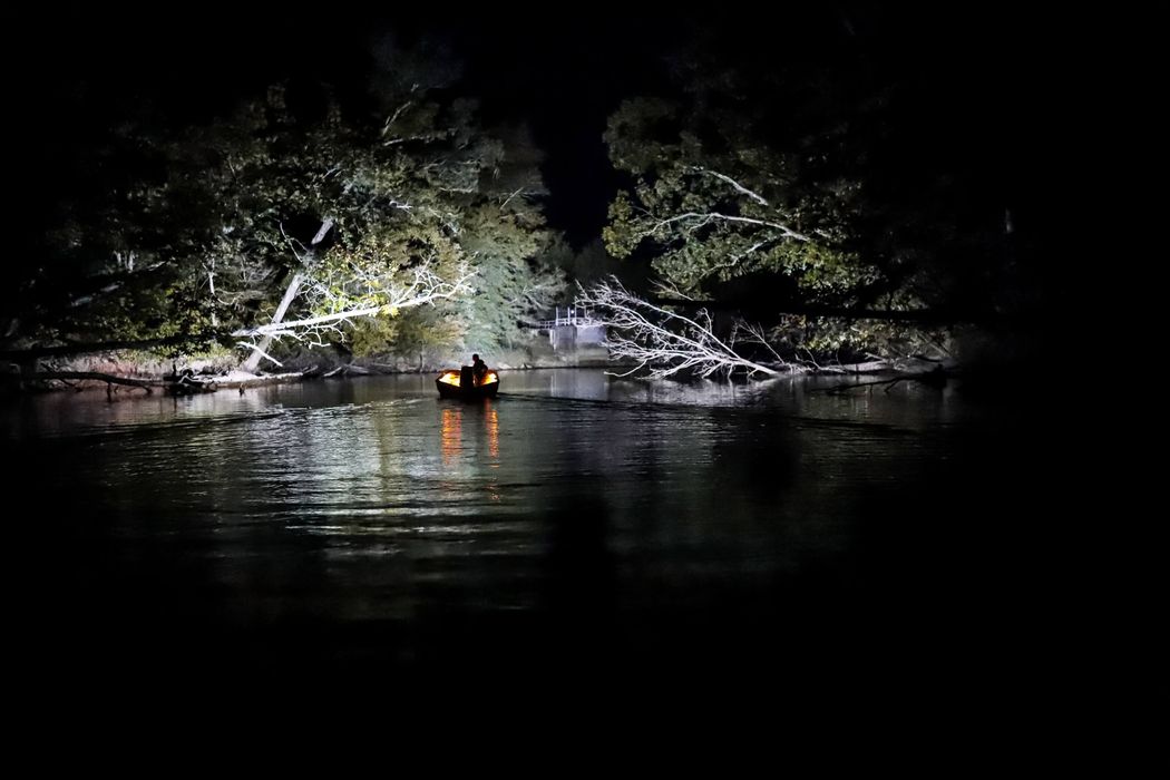 man with lit up boat at night