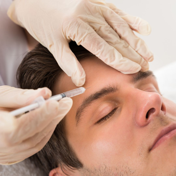 man getting botox injected into his forehead