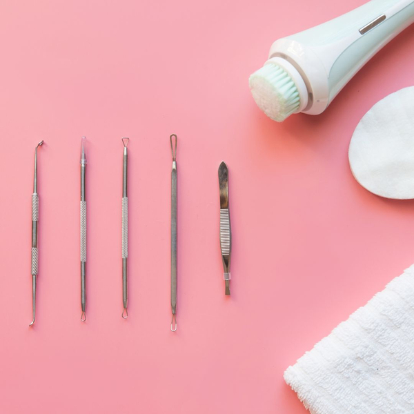 variety of tools laid out on pink background