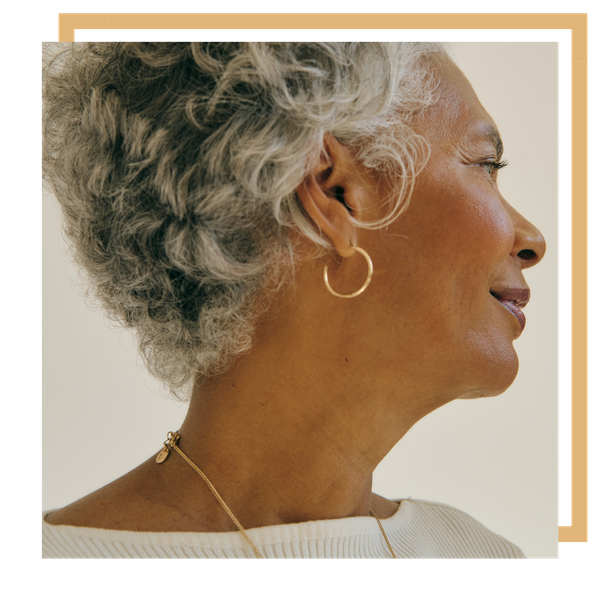 Older woman looking to the side wearing gold jewlery