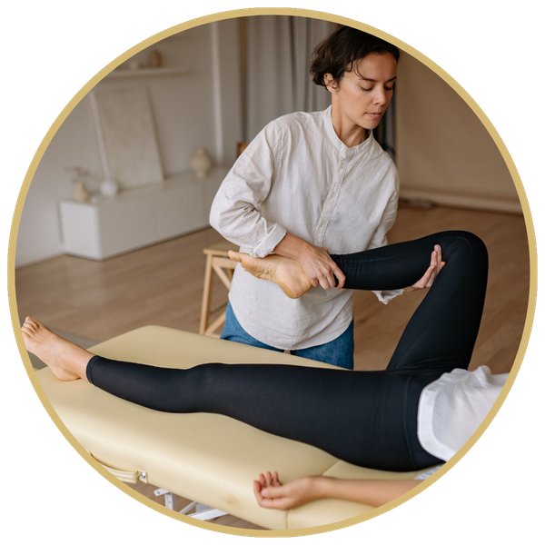 A masseuse stretching a client's leg