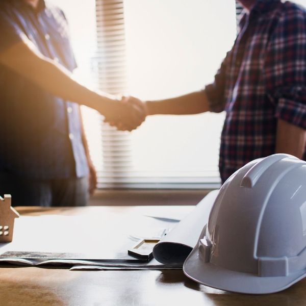 shaking hands with contractor, hard hat in foreground