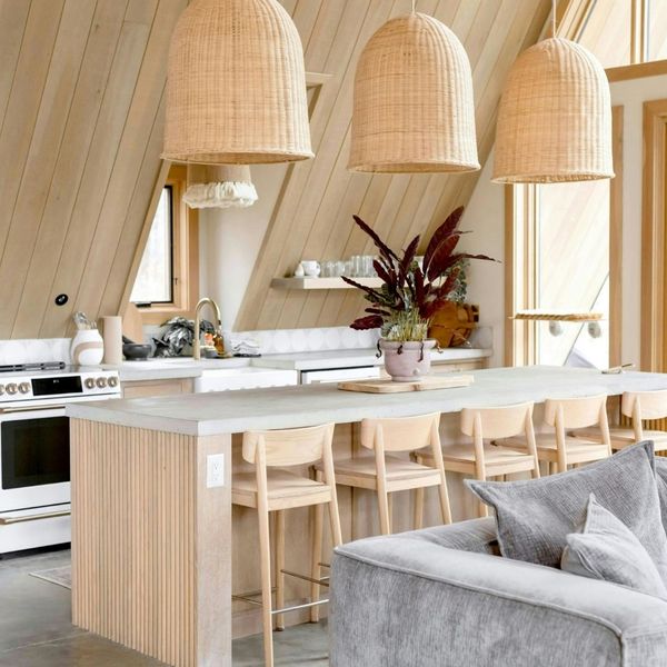 kitchen with row of chair stools at long island, woven overhead lights