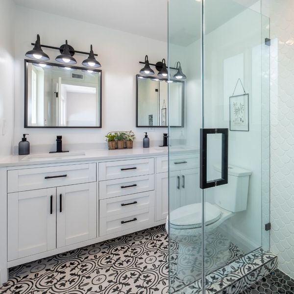 white and black bathroom, patterned tile floor, glass shower door