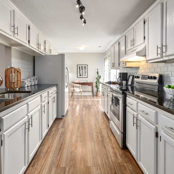 galley kitchen, light gray cabinets, hardwood floors