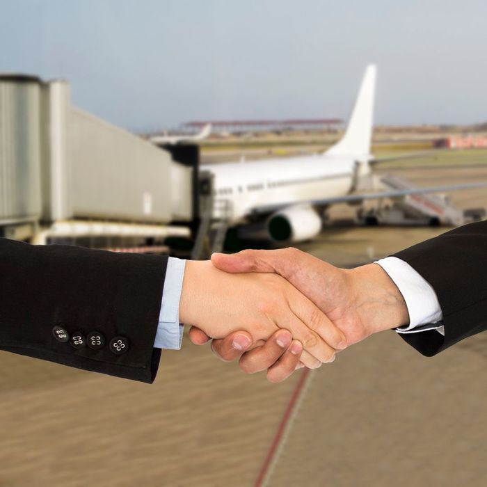 Shaking hands in front of a plane 