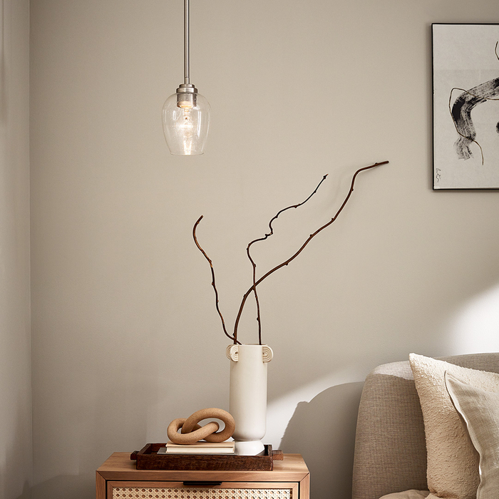 A pendant light hanging over a bedside table