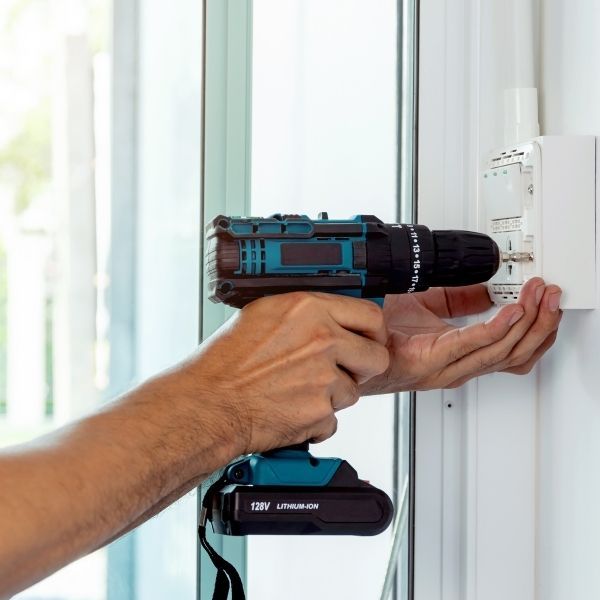 electrician drilling into an outlet