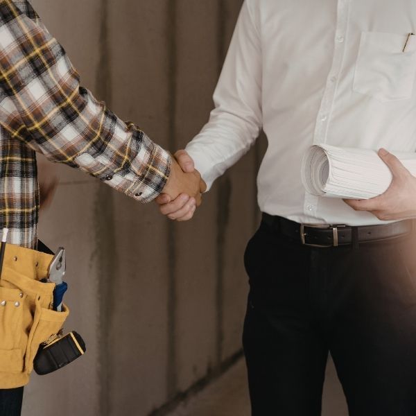 construction worker shaking business owner's hand