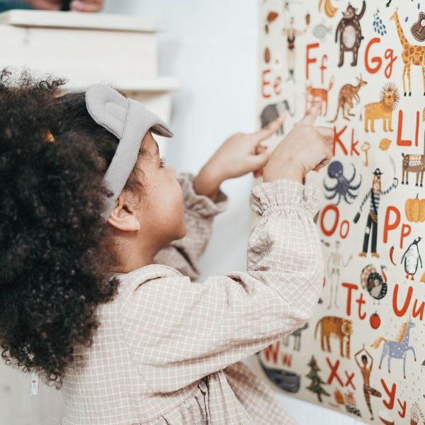 girl pointing to alphabet poster girl pointing to alphabet poster