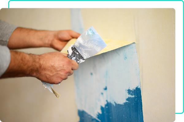 Hands removing wallpaper