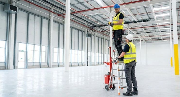 Professional installation team on-site, modern facility, installing sprinkler system.