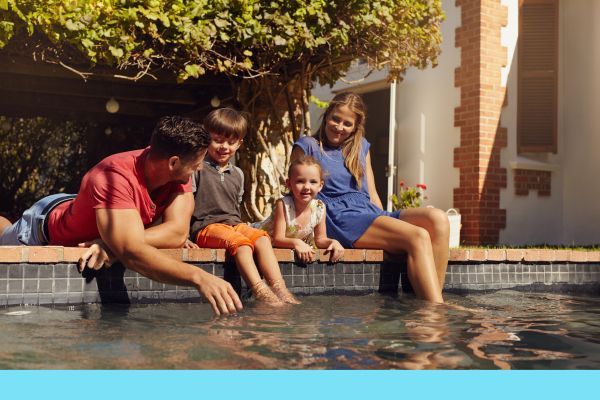 family dangling feet in pool