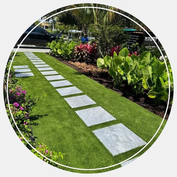 Stone paver walkway integrated with green synthetic turf Stone paver walkway integrated with green synthetic turf