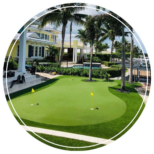 Custom backyard putting green with yellow flags near pool