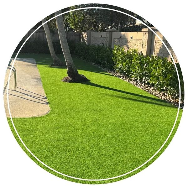 Poolside artificial grass lawn surrounded by palm trees