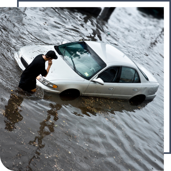 man on the phone while his car is flooded