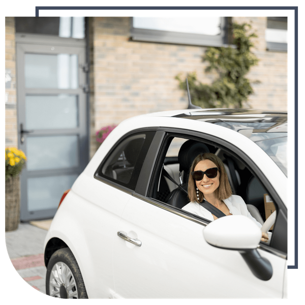 woman in her car outside her home 