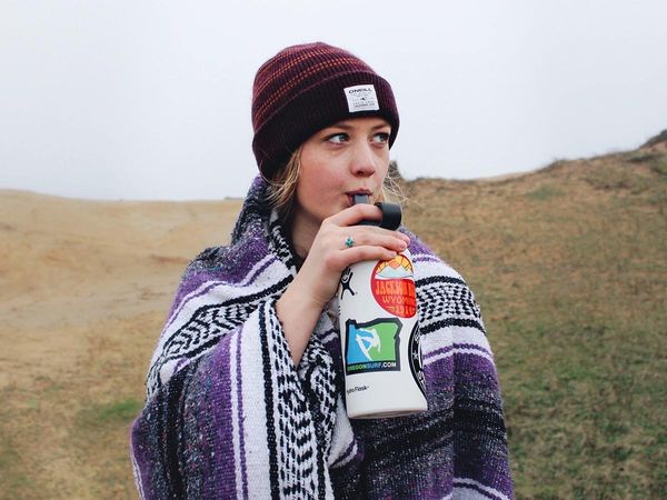 image of a woman drinking from a bottle wearing a poncho