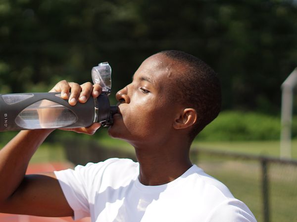 image of a runner drinking water