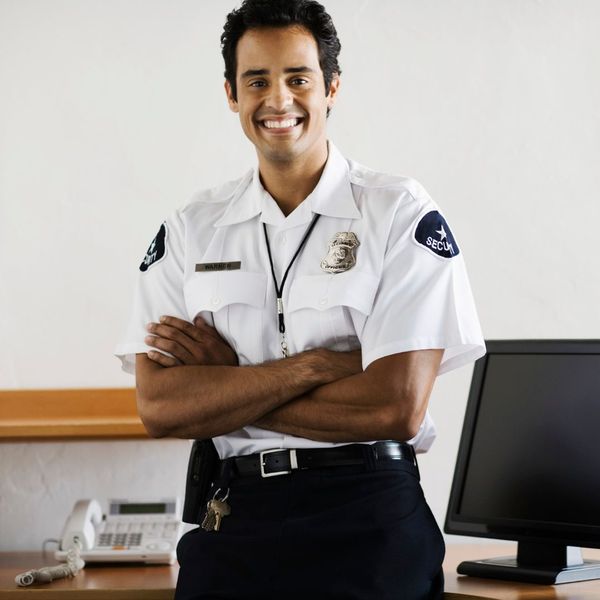 a smiling security guard at a desk