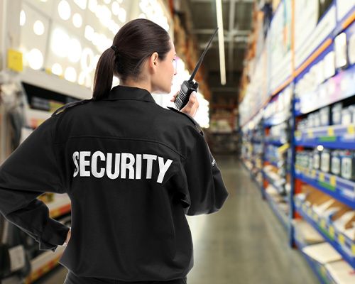 a security woman on a walkie talkie in a warehouse