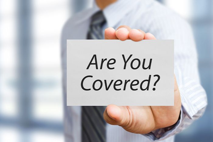 a businessman holding "are you covered?" sign