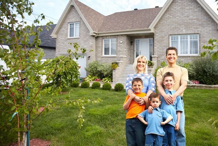 a family of 5 in front of their house