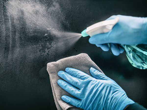 Image of a cleaning product being sprayed onto a surface. 