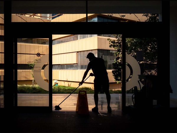 A silhouette of a person cleaning an office.