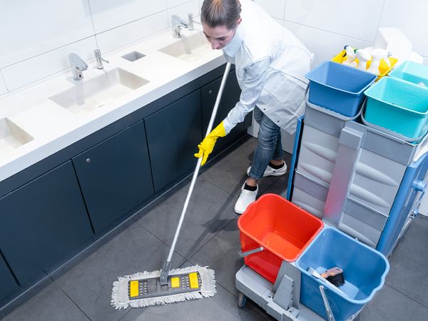  A woman mopping the floor of a business. 