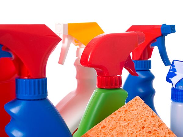 Image of assorted cleaning supplies, including a bucket, sponge, and five multi-colored cleaning sprays. 