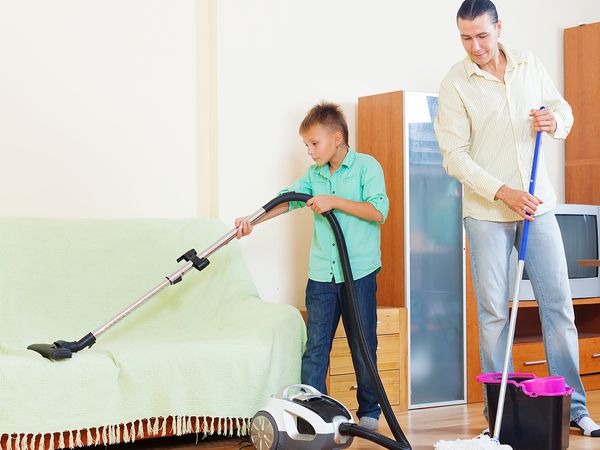  Image of two adults and a young boy cleaning a home