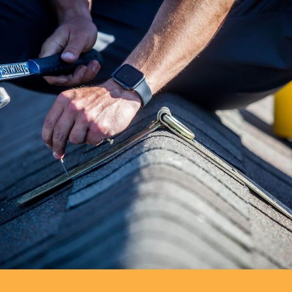 roofer attaching his harness to the roof