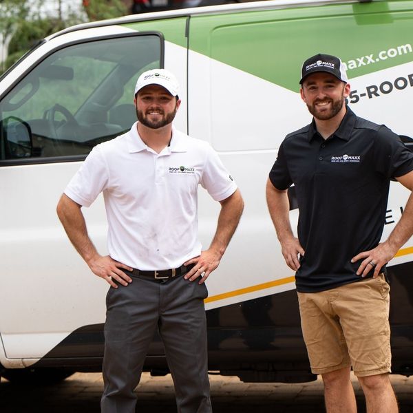 Guaranteed Roof employees in front of a Roof Maxx van