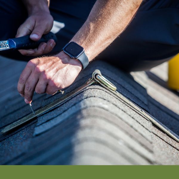 Hammering a nail into roof shingles