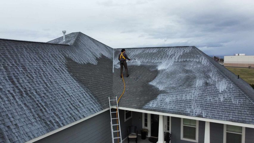view of a roofer cleaning a roof view of a roofer cleaning a roof