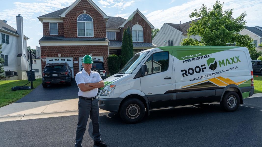 Guaranteed Roofing tech standing in front of van Guaranteed Roofing tech standing in front of van