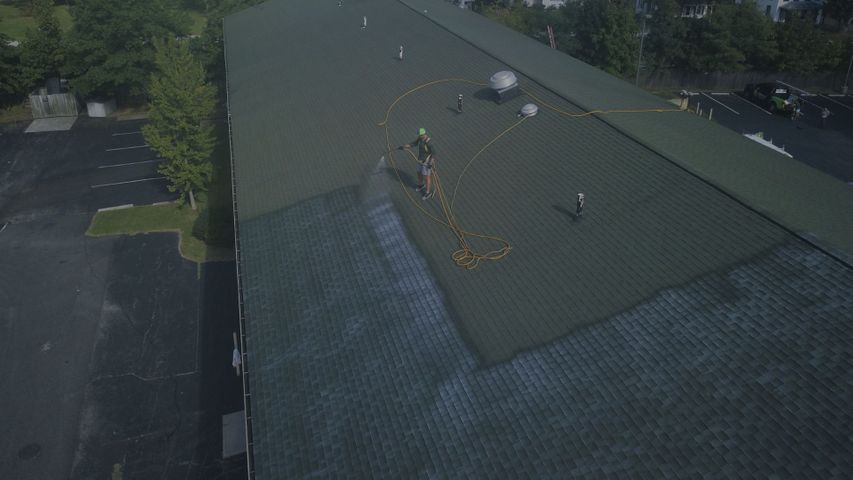 a person spraying a large roof Top Roofers in Georgia Hero.jpg