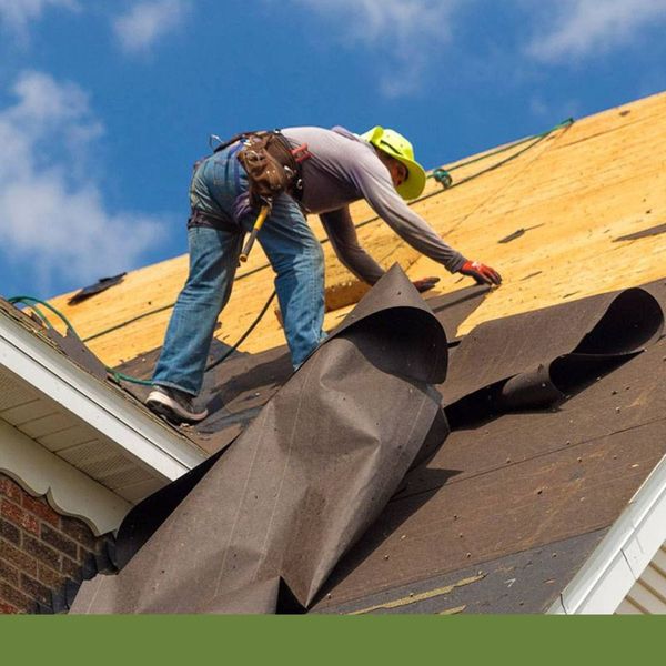Roofer installing tar paper on a new roof. Roofer installing tar paper on a new roof.