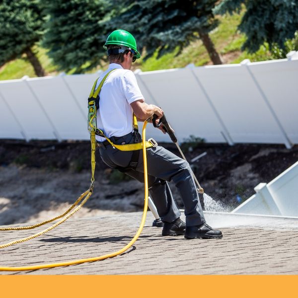 Man cleaning roof with shampoo spray